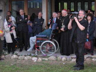 Il vicepresidente Igino Piutti spiega al monsignor Brollo e ai presenti il monumento dedicato a don Onelio